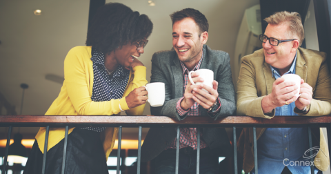 Three colleagues laughing together at work